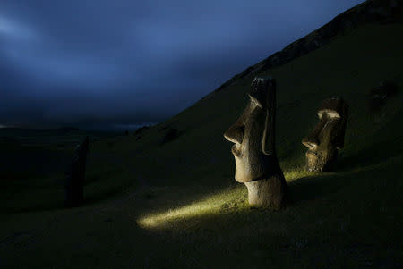 FILE PHOTO: A view of "Moai" statues in Rano Raraku volcano, on Easter Island, 4,000 km (2,486 miles) west of Santiago, Oct. 31, 2003. Easter Island's mysterious "Moai", giant head statues carved out of volcanic rock, are in danger of being destroyed by years of tropical rains and wind as well as careless humans and farm animals. Experts have called on the international community to commit funds to preserve the monoliths, whose mystery draws tourists to the world's most remote inhabited island. REUTERS/Carlos Barria