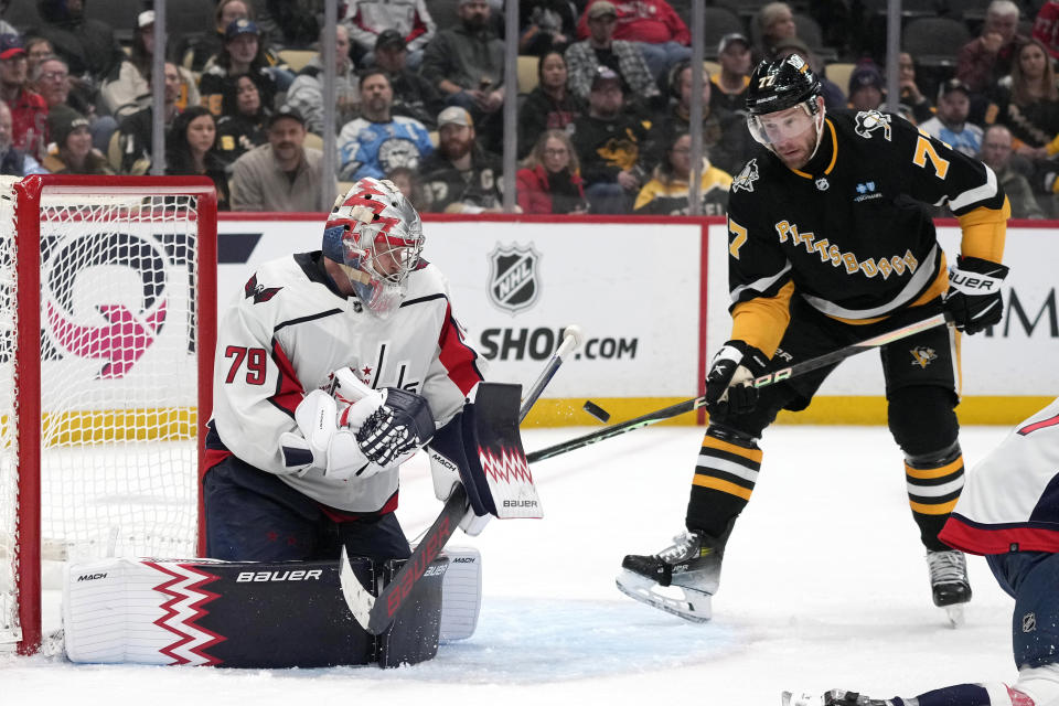 Washington Capitals goaltender Charlie Lindgren (79) blocks a shot with Pittsburgh Penguins' Jeff Carter (77) unable to get his stick on the rebound during the second period of an NHL hockey game in Pittsburgh, Thursday, March 7, 2024. (AP Photo/Gene J. Puskar)