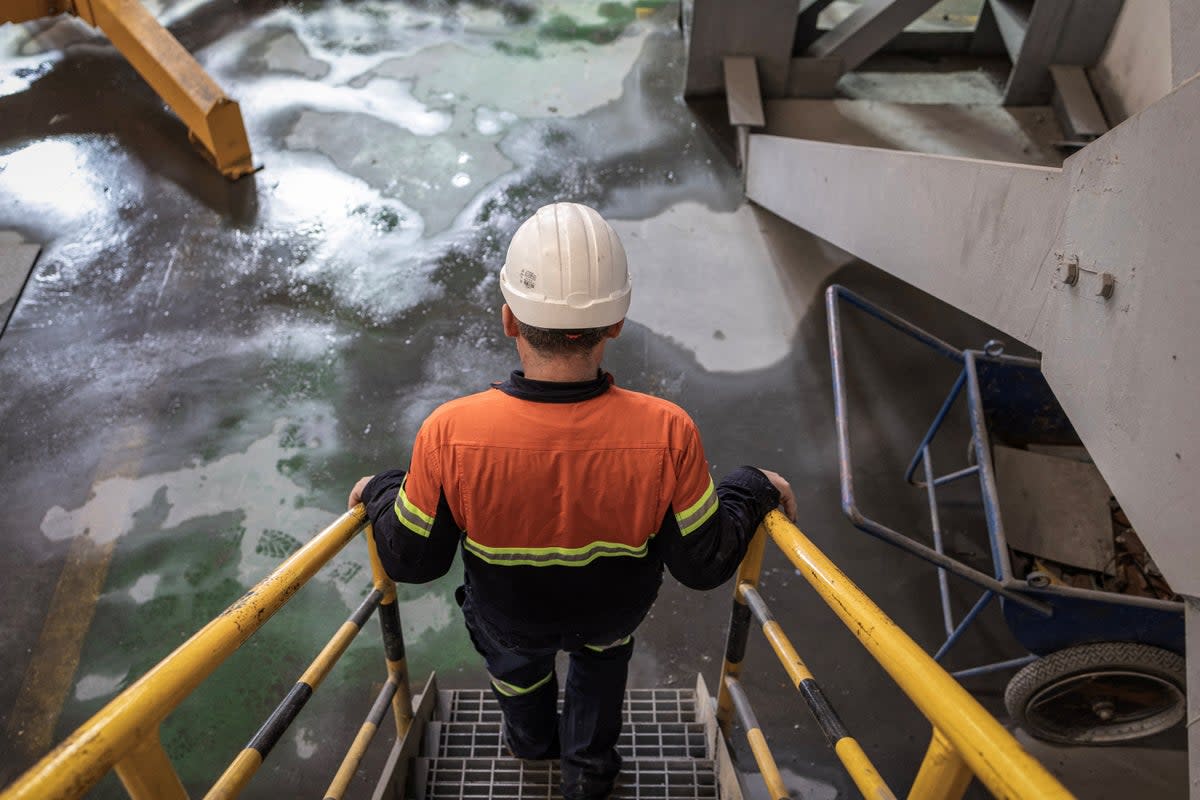 A worker walks down the stairs inside the mill facility of a copper mine (Reuters)