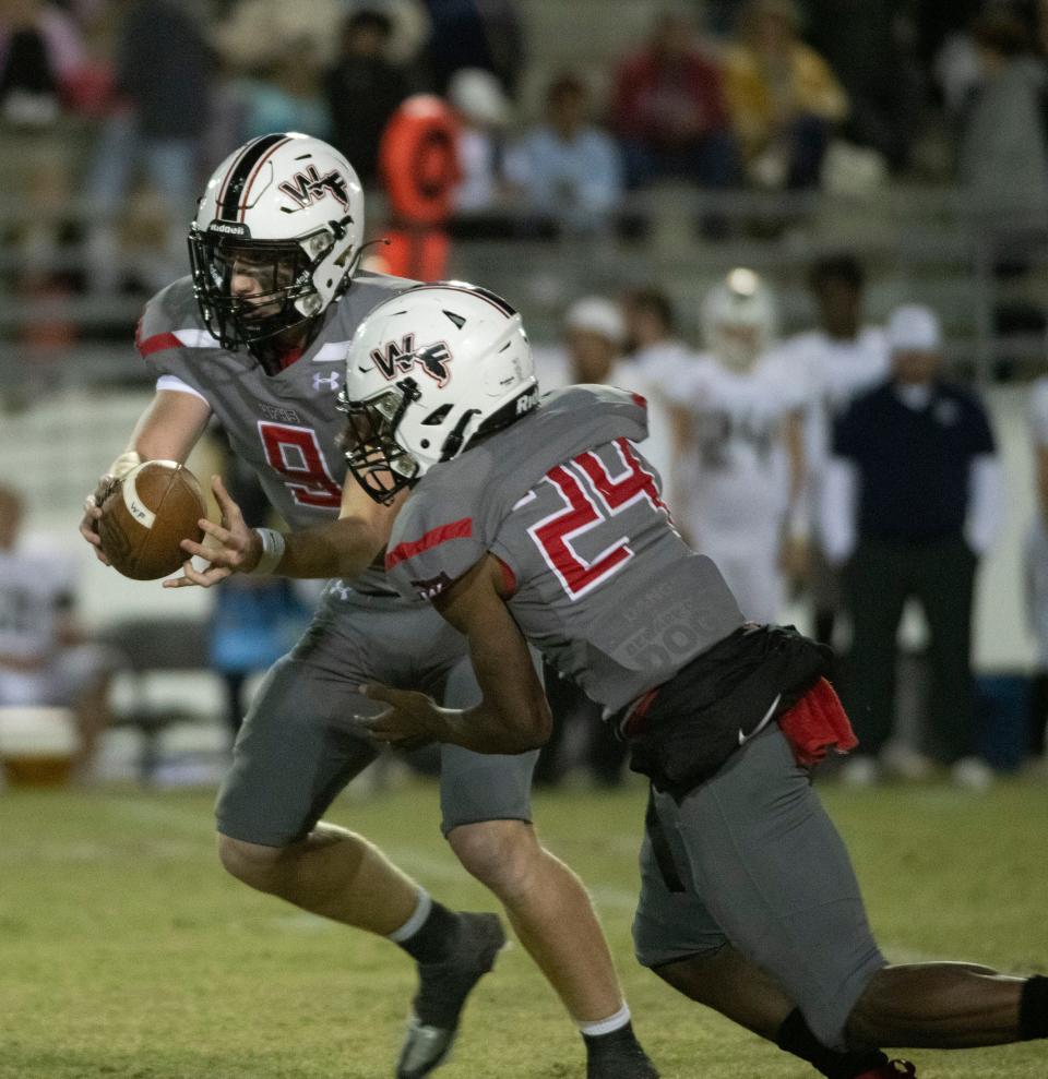 West Florida's John Nicholas (No. 9) hands the ball off to Marquez Jones (No. 24) as he looks for the first down during Thursday night's game against Gulf Breeze.