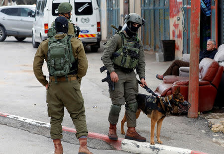 A Palestinian man sits as Israeli forces search for a Palestinian gunman in Beit Fourik, in the occupied West Bank March 17, 2019. REUTERS/Mohamad Torokman