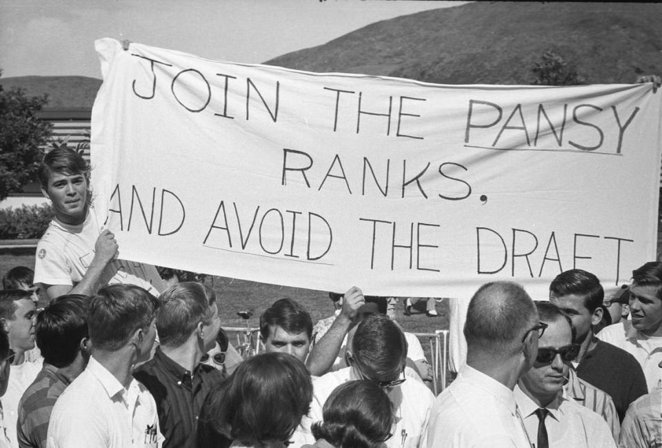 About 350 people attended a Cal Poly debate on the Vietnam War on Oct. 21, 1965. Hecklers held a banner that read, “Join the pansy ranks, and avoid the draft.”