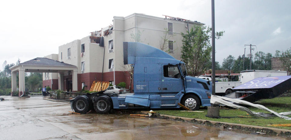A semi tractor sits on top of the sign of the Sleep Inn located on North Gloster Street in Tupelo, Miss, after a tornado touched down on Monday, April 28, 2014.(AP Photo/Jim Lytle)