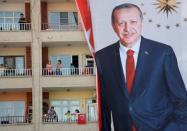 People watch an election rally of Turkish President Tayyip Erdogan from a building in Mardin, capital of Mardin province in southeastern Turkey, June 20, 2018. REUTERS/Goran Tomasevic