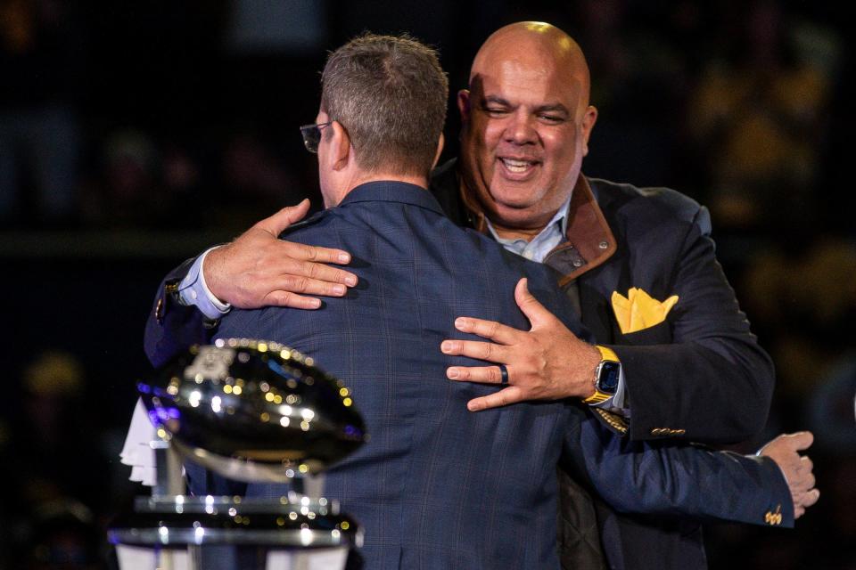 Michigan head coach Jim Harbaugh hugs athletic director Warde Manuel during the national championship celebration at Crisler Center in Ann Arbor on Saturday, Jan. 13, 2024.