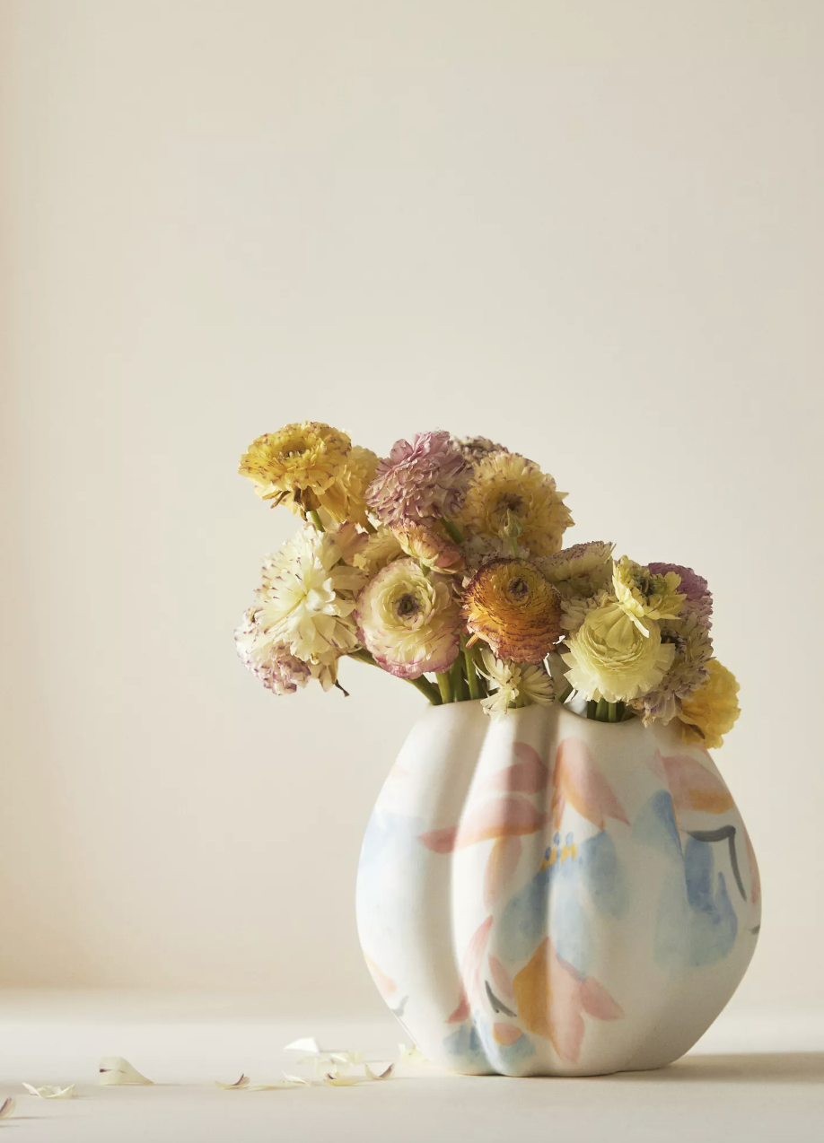 white Oreiller Vase with blue, orange and pink design and yellow flowers (photo via Anthropologie)