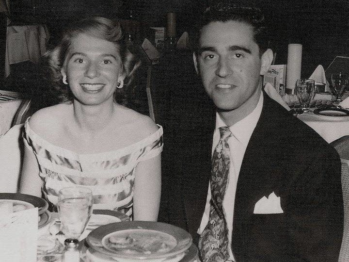 A black and white photograph of Marta Fainberg pictured having dinner in the 1950s with her husband, Seymour.