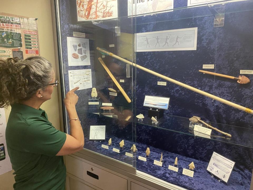 Cat Nolan, archaeology collections manager with Eglin’s Cultural Resources Office, points to a replica of an ancient spear and dart launcher called an atlatl in the Jackson Guard Natural Resources Office.