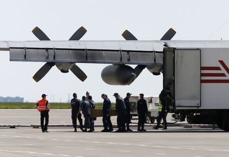 People carry a coffin containing the remains of one of the victims of the Malaysia Airlines MH17 downed over rebel-held territory in eastern Ukraine before loading it on a transport plane heading towards the Netherlands at Kharkiv airport July 23, 2014. REUTERS/Gleb Garanich