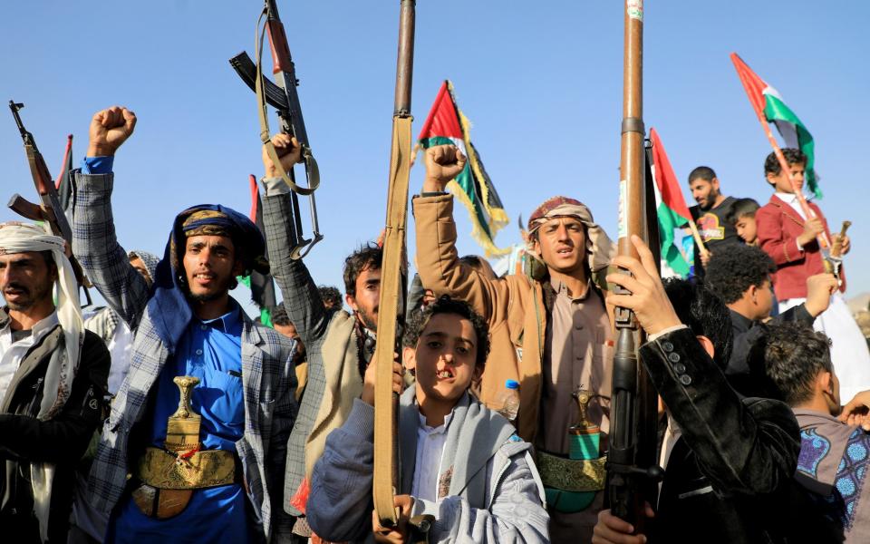 Huthi fighters brandish their weapons during a protest following US and British forces strikes, in the Huthi-controlled capital Sanaa on January 12, 2024 amid the ongoing battles between Israel and the militant Hamas group in Gaza. US and British forces struck rebel-held Yemen early on January 12, after weeks of disruptive attacks on Red Sea shipping by the Iran-backed Huthis who say they act in solidarity with Gaza. The pre-dawn air strikes add to escalating fears of wider conflict in the region, where violence involving Tehran-aligned groups in Yemen as well as Lebanon, Iraq and Syria has surged since the Israel-Hamas was began in early October. (Photo by MOHAMMED HUWAIS / AFP) (Photo by MOHAMMED HUWAIS/AFP via Getty Images)
