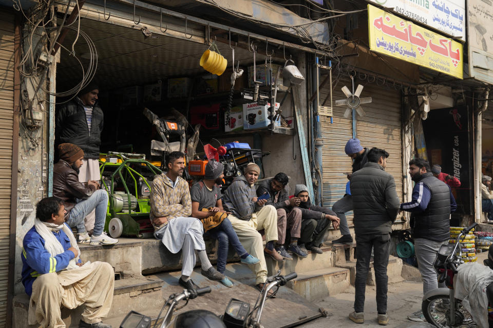 Shopkeepers and workers wait for electric power at a market following a power breakdown across the country, in Lahore, Pakistan, Monday, Jan. 23, 2023. Much of Pakistan was left without power for several hours on Monday morning as an energy-saving measure by the government backfired. The outage spread panic and raised questions about the cash-strapped government’s handling of the crisis. (AP Photo/K.M. Chaudary)