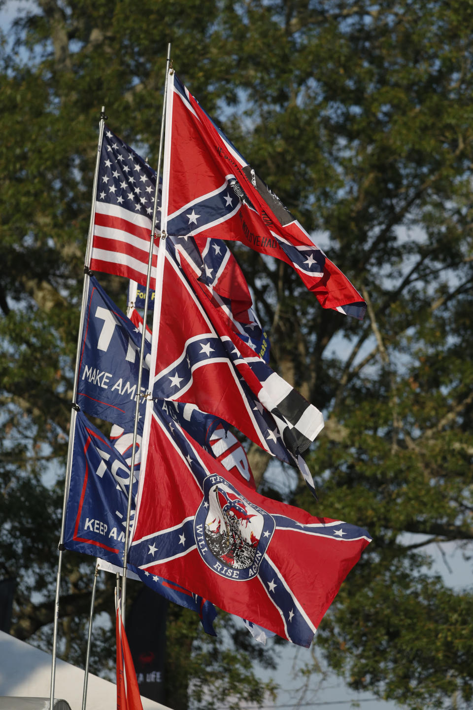 A vendor displays Confederate Battle flags as well as Trump 2020 flags across from the Speedway during the NASCAR Xfinity auto race at the Talladega Superspeedway in Talladega Ala., Saturday June 20, 2020 (AP Photo/John Bazemore)