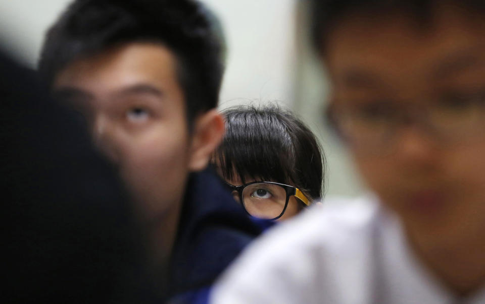 In this Dec. 9, 2013 photo, students attend an English grammar lesson by Tony Chow in a classroom of Modern Education in Hong Kong. The 30-year-old teaches English grammar to thousands of secondary school pupils, who attend his after-school lessons or watch video replays of them at Modern Education’s 14 branches. Chow is a celebrity tutor in Hong Kong, where there’s big money to be made offering extracurricular lessons to parents desperately seeking an edge for their children preparing for the city’s intense public entrance exam for university. (AP Photo/Kin Cheung)