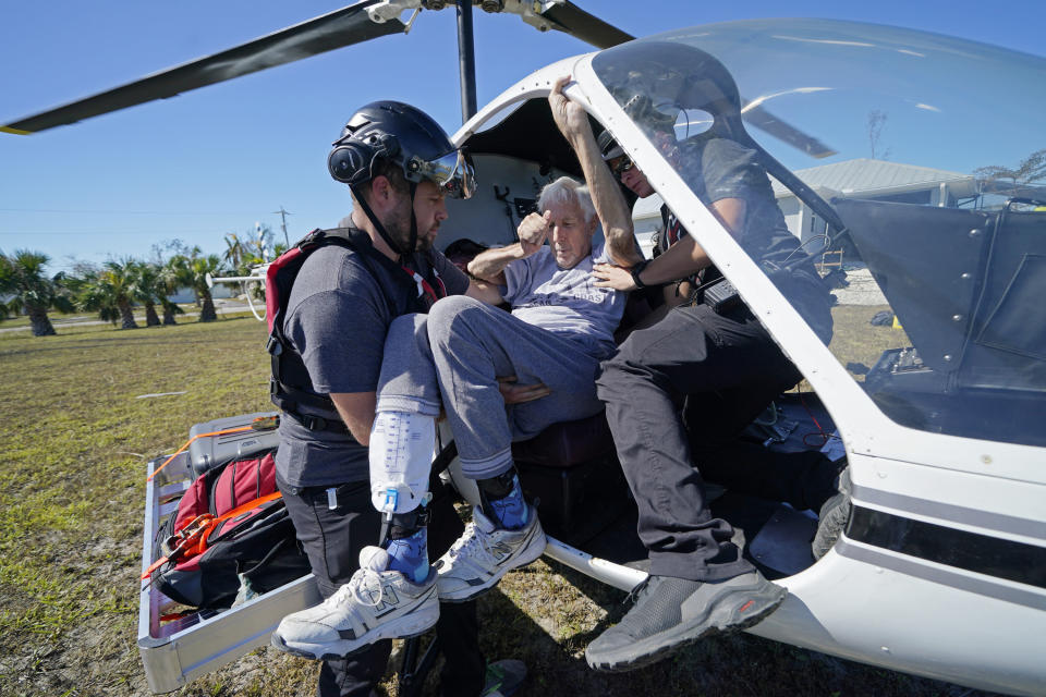 FILE - Members of mediccorps.org help evacuate Tom Acerbo in the aftermath of Hurricane Ian on Pine Island, Fla., Saturday, Oct. 1, 2022. The group arrived on the island with two helicopters, paramedics and volunteers, as the only bridge to the island was heavily damaged so the only access is by boat or air. Older people with limited mobility and those with chronic health conditions were especially vulnerable when Hurricane Ian slammed into Southwest Florida. (AP Photo/Gerald Herbert, File)