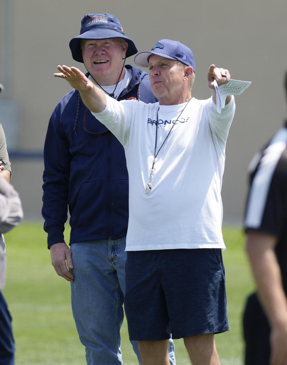 FILE - Denver Broncos head coach Sean Payton, front, chats with retired Broncos linebacker Karl Mecklenburg during NFL football practice, Wednesday, June 14, 2023, in Centennial, Colo. Sean Payton is back on the sideline and this time it's in Denver. The former Saints head coach was hired after spending a year in the broadcast booth. (AP Photo/David Zalubowski, File)