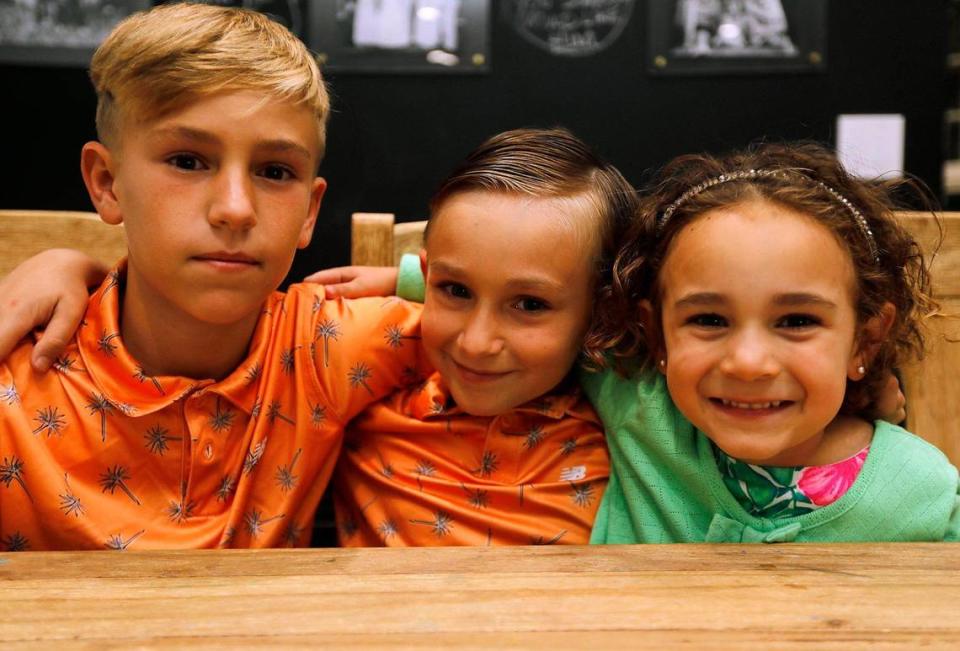 (C) Logan Jenner, de 8 años, ex paciente de cáncer en el Hospital Infantil Nicklaus junto a su hermano (L) Ashton Jenner, de 10 años, y su hermana (R) Mary, de 4 años, en su casa de Miami-Dade, el lunes 4 de marzo de 2024. Logan fue uno de los pacientes inscritos en un nuevo ensayo clínico de la FIU que pretendía crear un enfoque más personalizado del tratamiento del cáncer mediante el uso de la medicina de precisión funcional, conocida como FPM, que usa pruebas de sensibilidad a los medicamentos y perfiles genómicos para analizar e identificar qué fármacos serían más eficaces contra el cáncer.