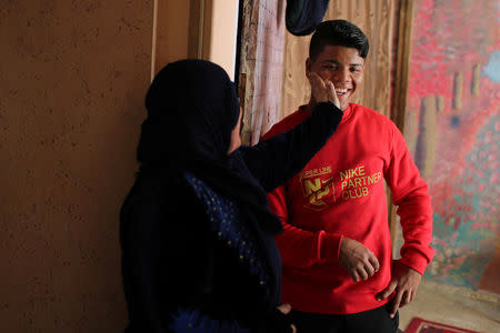 Palestinian Mustafa Sarhan, 19, a member of Gaza Skating Team, smiles as he is touched by his mother in their house in Gaza City March 18, 2019. REUTERS/Mohammed Salem
