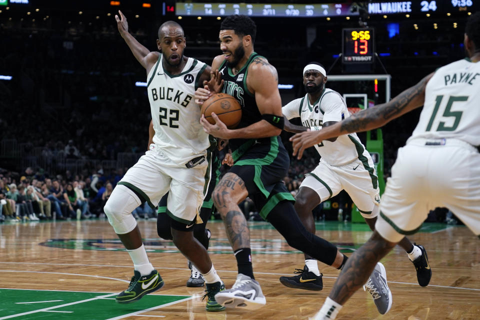 Boston Celtics forward Jayson Tatum, center, drives to the basket against Milwaukee Bucks forward Khris Middleton (22) during the first half of an NBA basketball game, Wednesday, Nov. 22, 2023, in Boston. (AP Photo/Charles Krupa)