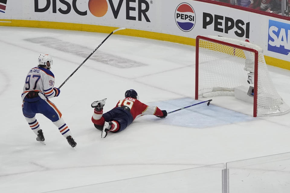 Florida Panthers left wing Matthew Tkachuk (19) attempts to stop a goal by Edmonton Oilers center Connor McDavid (97) during the third period of Game 5 of the NHL hockey Stanley Cup Finals, Tuesday, June 18, 2024, in Sunrise, Fla. The Oilers defeated the Panthers 5-3. (AP Photo/Rebecca Blackwell)