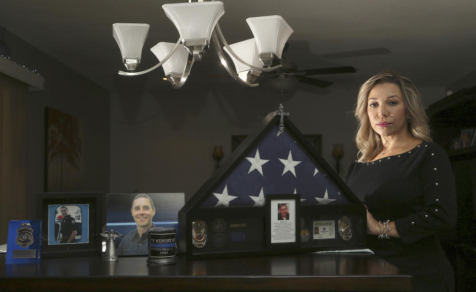 Rebecca Tiger, a former Phoenix police officer, is the widow of Craig Tiger, a Phoenix police officer who committed suicide a few years ago following a fatal shooting he was involved in, shown at her home Monday, July 1, 2019, in Scottsdale, Ariz. Officer Craig Tiger suffered from post-traumatic stress disorder after fatally shooting a man while on duty back in 2012, and took his own life two years later. (AP Photo/Ross D. Franklin)