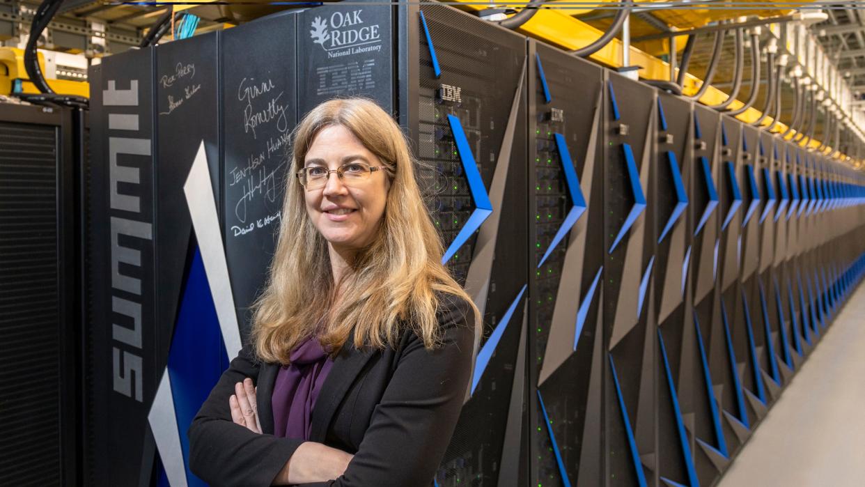 Melissa Dumas, a climate researcher stands with the Summit supercomputer, in this Jan. 25, 2021 photo.