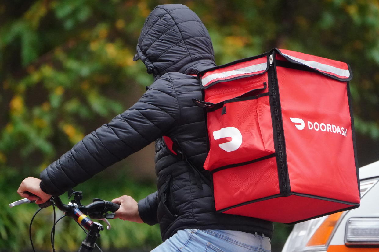 A delivery person for DoorDash rides his bike in the rain during the coronavirus disease (COVID-19) pandemic in New York City, November 13, 2020. REUTERS/Carlo Allegri