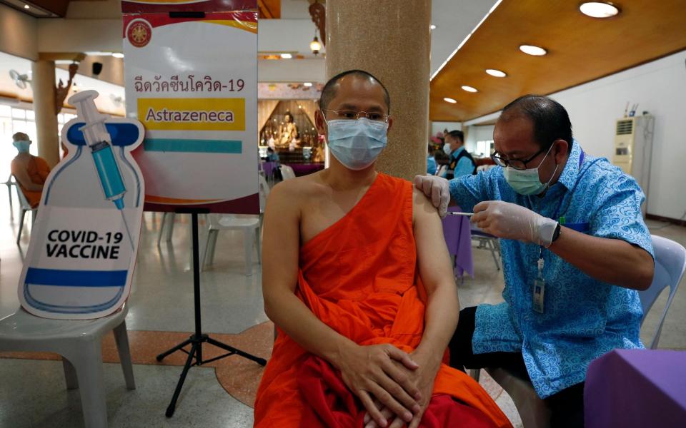 A Thai Buddhist monk receives a vaccine in Bangkok - Shutterstock