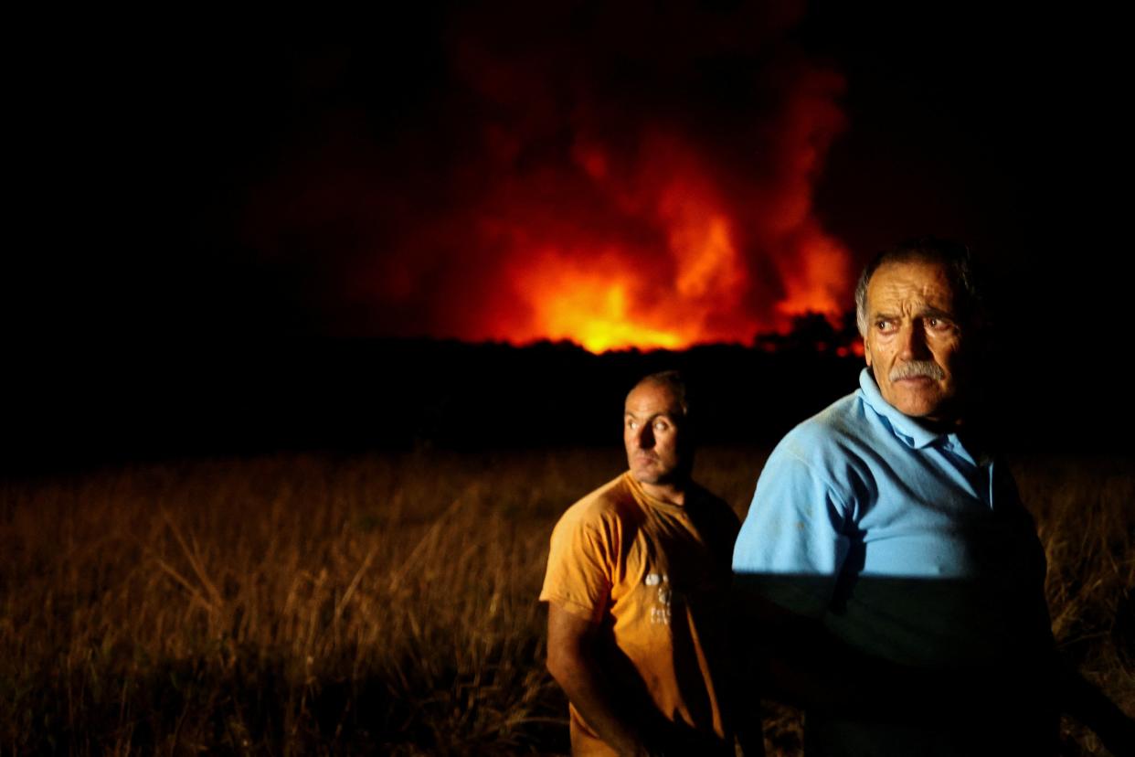 People watch a wildfire in Aljezur, Portugal (REUTERS)