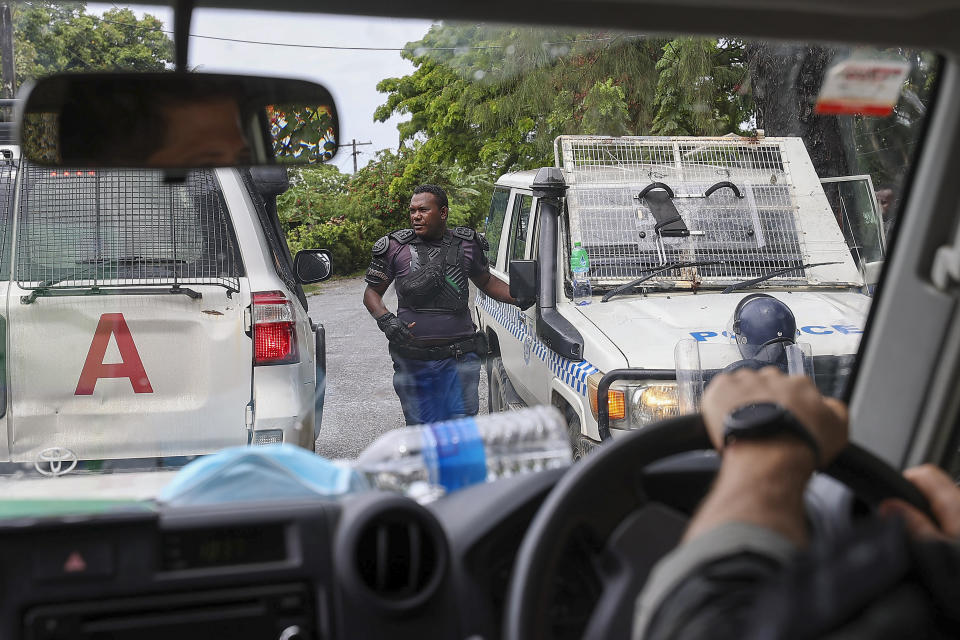 Australian Federal Police drive through the streets of Honiara, Solomon Islands, Monday, Dec. 6, 2021. Lawmakers in the Solomon Islands are debating whether they still have confidence in the prime minister, after rioters last month set fire to buildings and looted stores in the capital. (Gary Ramage via AP)