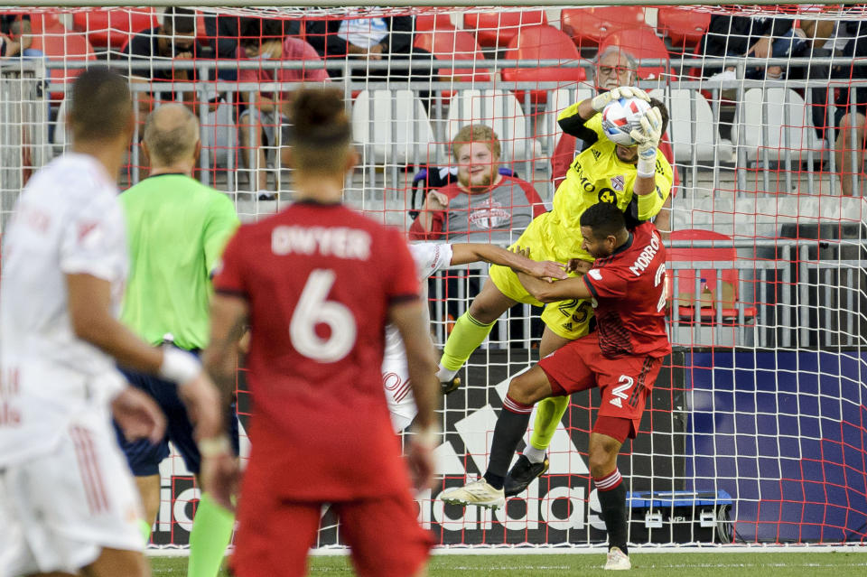 Toronto FC goalkeeper Alex Bono (25) and defender Justin Morrow (2) collide during the first half of the team's MLS soccer match against the New York Red Bulls on Wednesday, July 21, 2021, in Toronto. (Chris Katsarov/The Canadian Press via AP)