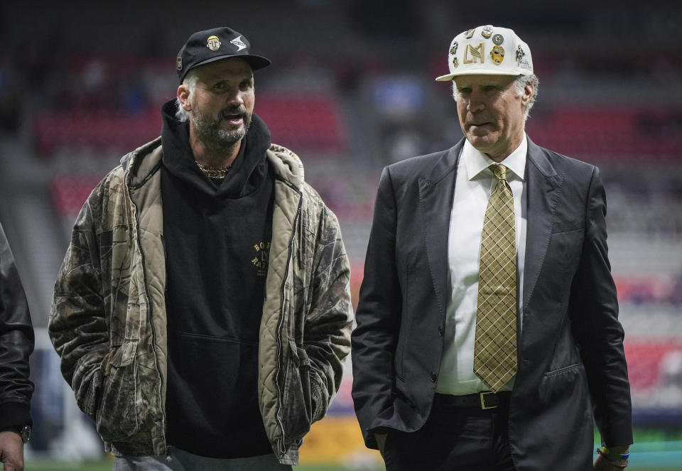 Los Angeles FC co-owners, Shaun Neff, left, and comedian and actor Will Ferrell, right, walk off the field before the Vancouver Whitecaps and LAFC play Game 2 of a first-round MLS playoff soccer match in Vancouver, British Columbia, Sunday, Nov. 5, 2023. (Darryl Dyck/The Canadian Press via AP)