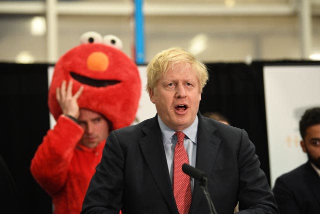 Prime minister Boris Johnson giving his victory speech after winning the Uxbridge & Ruislip South constituency in the 2019 with a man dressed in a red Elmo costume behind him 