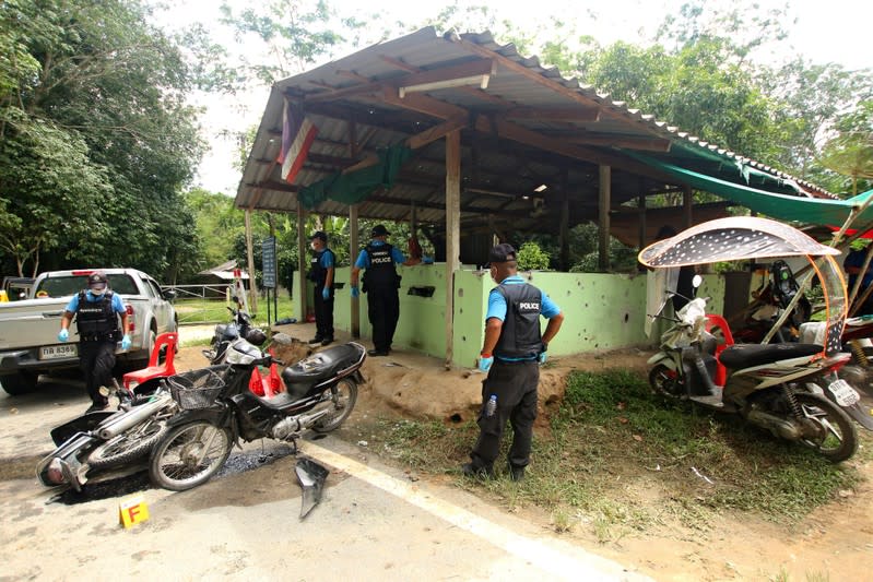 Thai forensic experts examine the site where village defence volunteers were killed by suspected separatist insurgents in Yala province