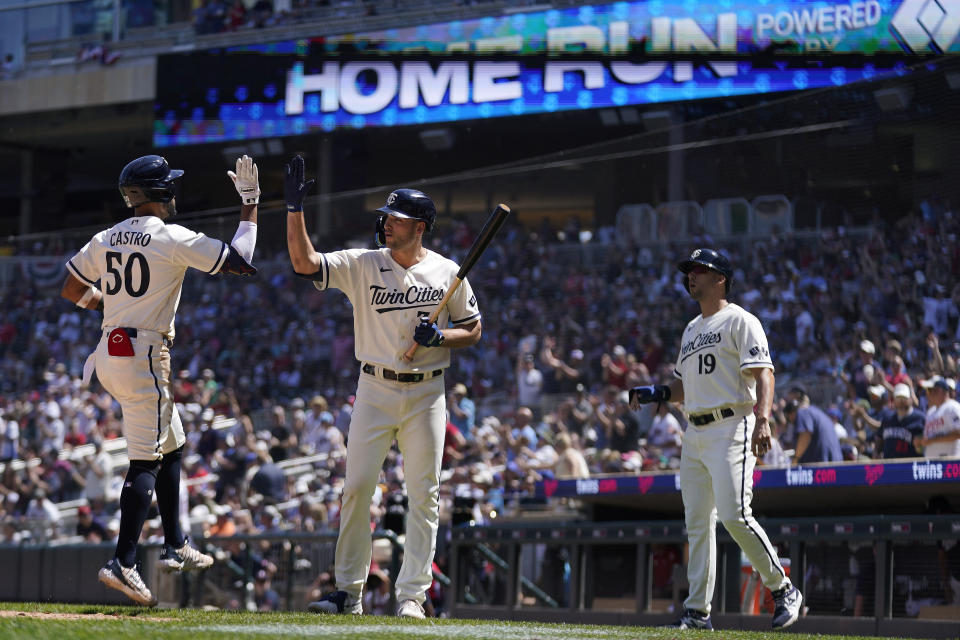 Minnesota Twins' Willi Castro (50), left, celebrates with Matt Wallner, middle, after hitting a two-run home run against the Toronto Blue Jays during the fifth inning of a baseball game Saturday, May 27, 2023, in Minneapolis. (AP Photo/Abbie Parr)