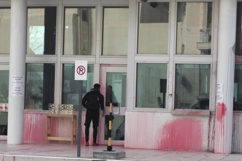 A man stands at an entrance of the US embassy in Greece, some hours after an anarchist group threw red paint, in Athens, on Monday, Jan. 7, 2019. Police said Monday that eight were detained after about 10 people on motorbikes threw red paint at the embassy's parking entrance at around 3:30 a.m. local time. An anarchist group known as Rouvikonas claimed responsibility for the attack in an internet post. (AP Photo/Petros Giannakouris)