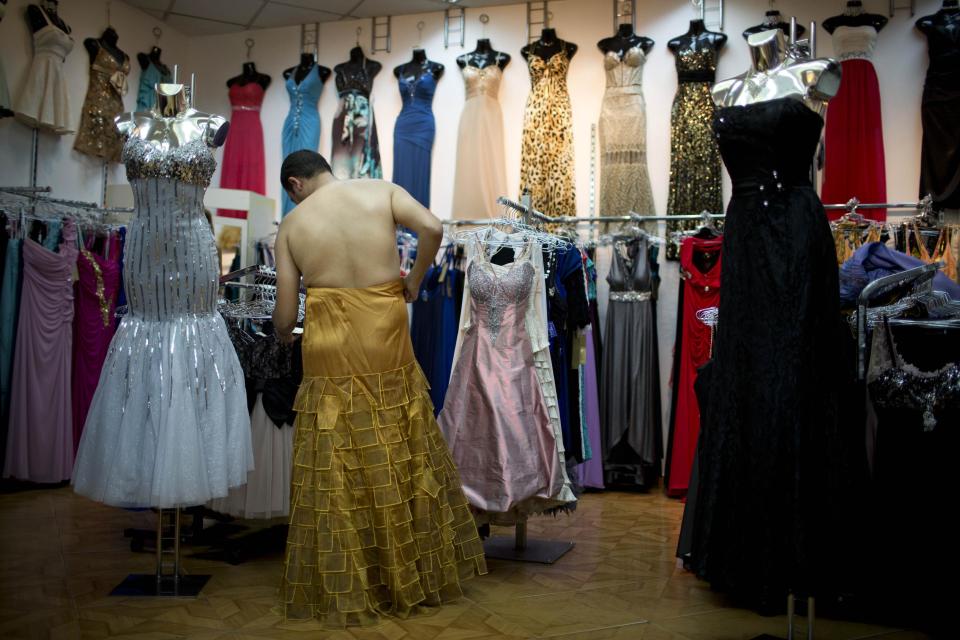 In this photo taken on Thursday, July 25, 2013, Israeli Orthodox Jew Shahar Hadar buys a woman's dress for his next drag queen show, in downtown Tel Aviv, Israel. Hadar, a telemarketer by day, has taken the gay Orthodox struggle from the synagogue to the stage, beginning to perform as one of Israel’s few religious drag queens. His drag persona is that of a rebbetzin, a female rabbinic advisor, a wholesome guise that stands out among the sarcastic and raunchy cast of characters on Israel’s drag queen circuit. (AP Photo/Oded Balilty)