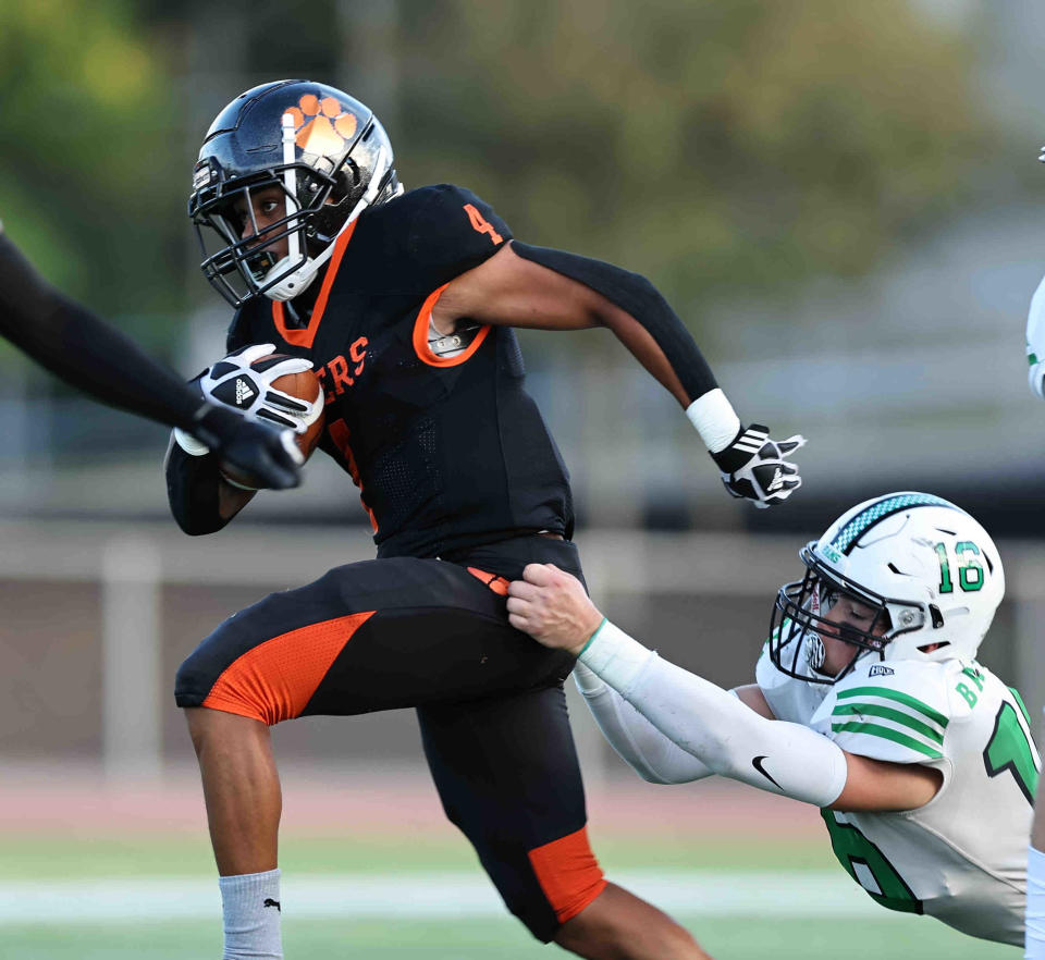 Withrow running back Auntuian Brown (4) is tackled by Hamilton Badin linebacker Reese Anzalone (16) during a football game between Withrow and Badin high schools Friday, Sept. 2, 2022.