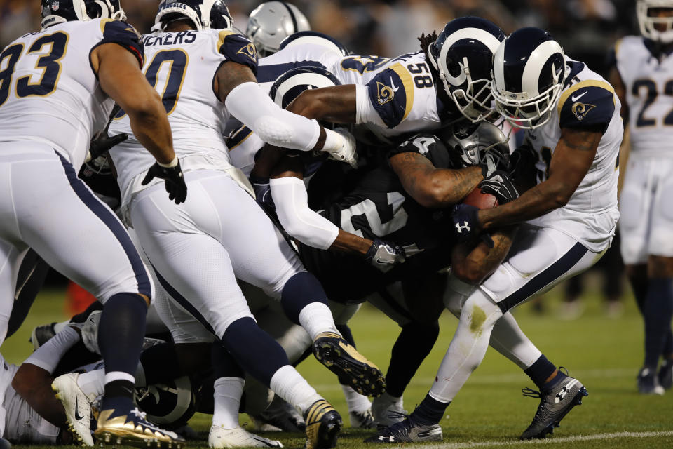 Oakland Raiders running back Marshawn Lynch carries the ball into the end zone for a touchdown as Los Angeles Rams linebacker Cory Littleton (58) tries to stop him during the first half of an NFL football game against the Los Angeles Rams in Oakland, Calif., Monday, Sept. 10, 2018. (AP Photo/John Hefti)