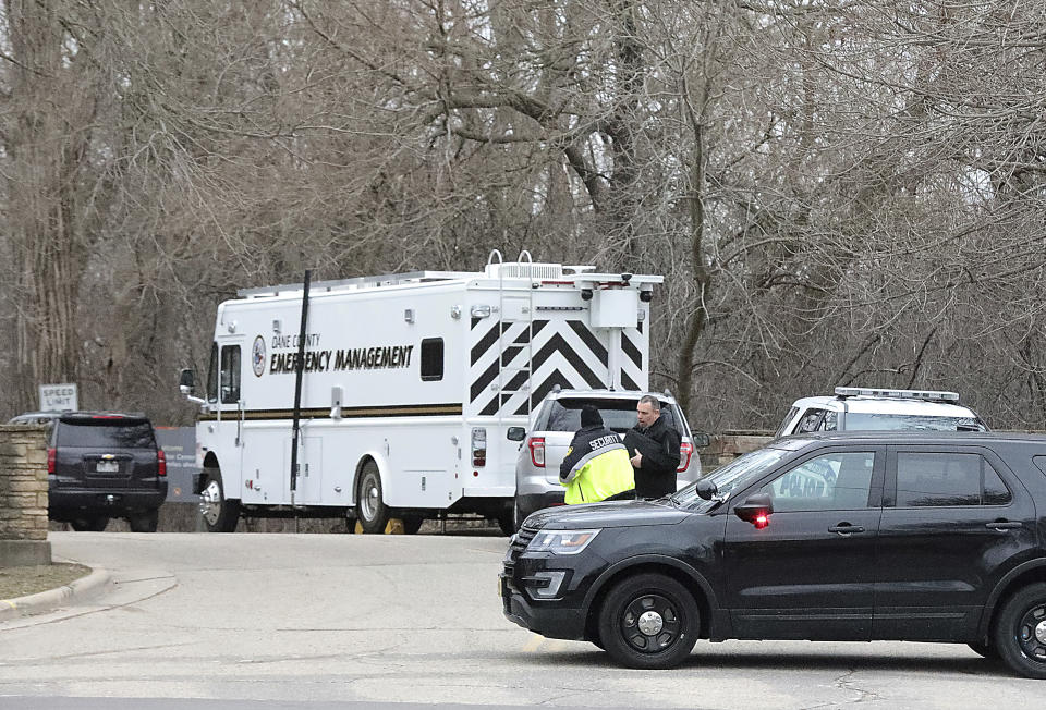 Vehicles from the Madison Police Department, Dane County Sheriff's Office and the University of Wisconsin Police Department are stationed at the entrance the UW-Arboretum in Madison, Wis. as law enforcement personnel investigate a double homicide Tuesday, March 31, 2020. (John Hart/Wisconsin State Journal via AP)