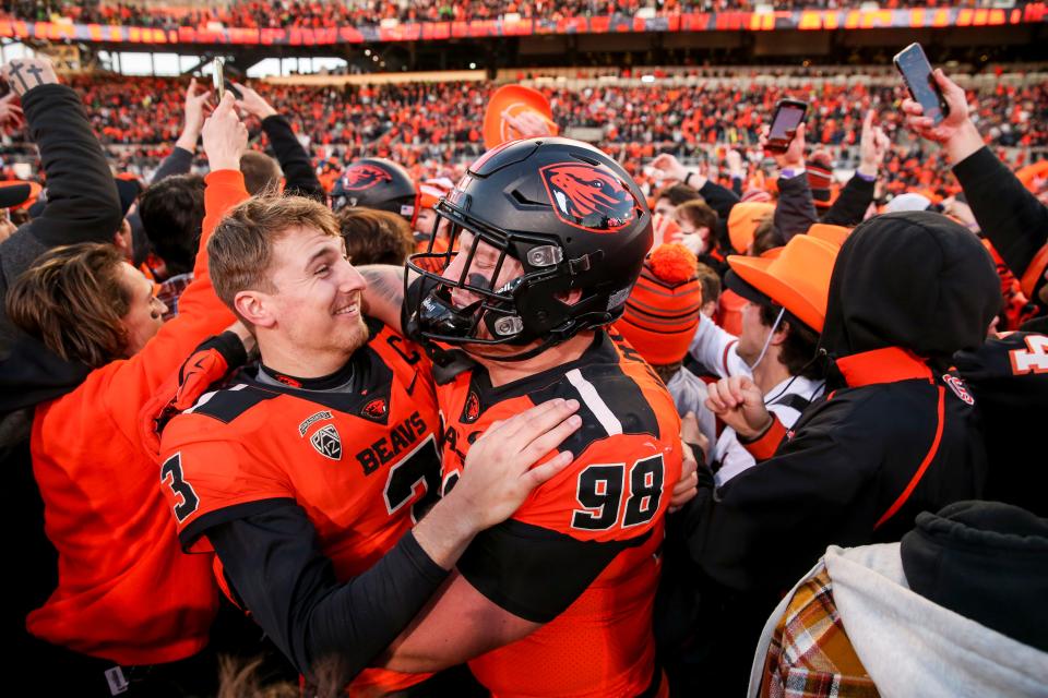 Oregon State quarterback Tristan Gebbia (3) hugs defensive lineman Cody Anderson after beating Oregon.