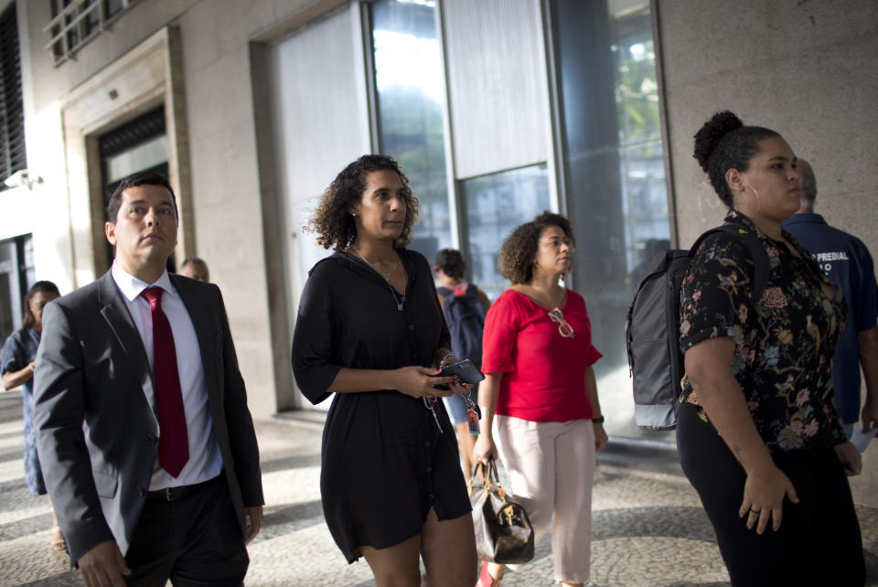 Anielle Franco, the sister of slain councilwoman Marielle Franco, second left, and her daughter Luyara Santos, right, leave the Public Prosecution Office after attending a press conference, in Rio de Janeiro, Brazil, Tuesday, March 12, 2019. Police in Brazil have arrested two former policemen in the killing of the councilwoman and her driver. The brazen assassination of the two on March 14 last year led to massive protests and widespread anger in Latin America's largest nation. (AP Photo/Silvia Izquierdo)