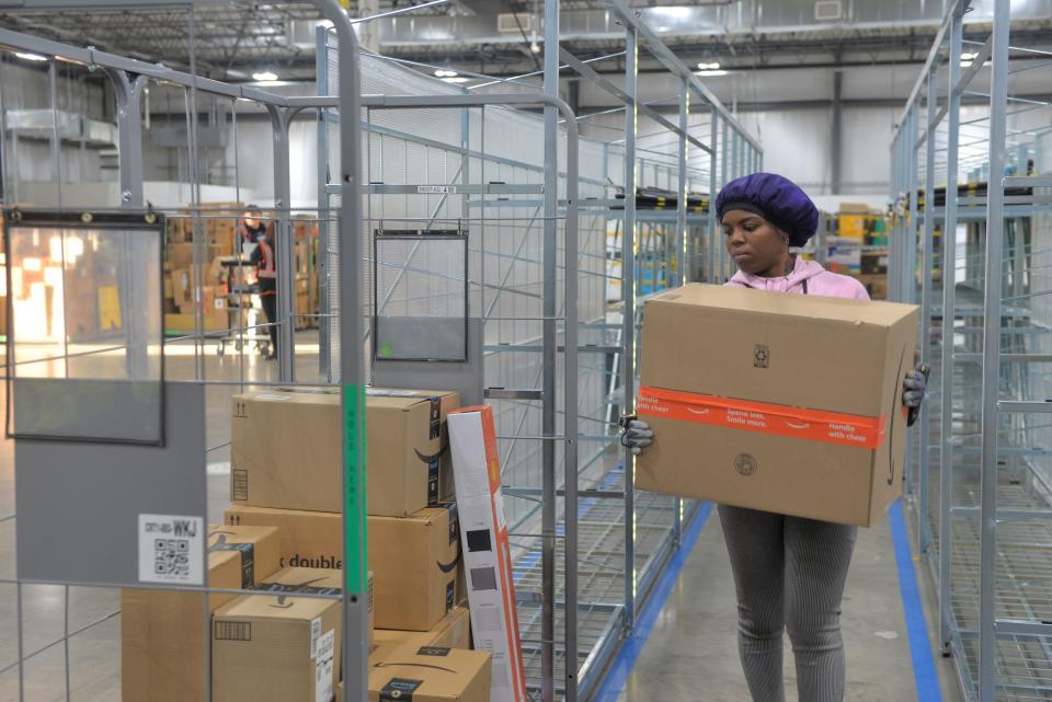 Amazon employee Marshida Williams loads a cart with packages to head out for delivery Wednesday, Nov. 23, 2022, in St. Cloud.