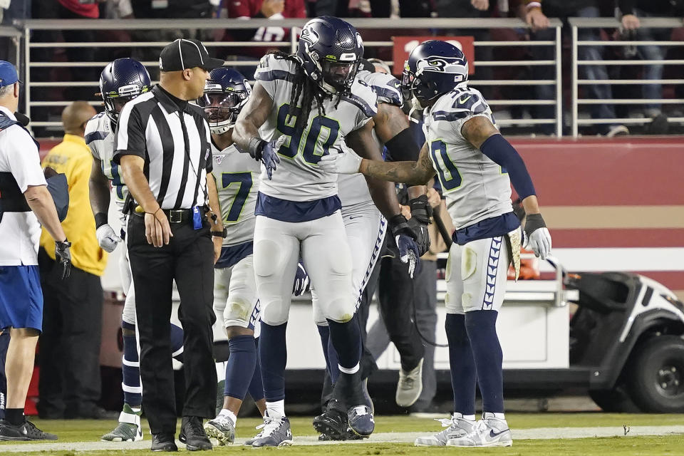 Seattle Seahawks defensive end Jadeveon Clowney (90) is congratulated by strong safety Bradley McDougald (30) after scoring against the San Francisco 49ers during the first half of an NFL football game in Santa Clara, Calif., Monday, Nov. 11, 2019. (AP Photo/Tony Avelar)