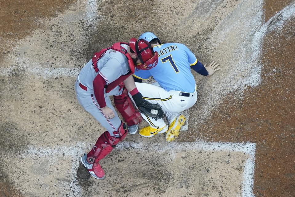 Cincinnati Reds catcher Austin Romine tags out Milwaukee Brewers' Victor Caratini at home during the sixth inning of a baseball game Saturday, Aug. 6, 2022, in Milwaukee. Caratini tried to score from second on a hit by Christian Yelich. (AP Photo/Morry Gash)