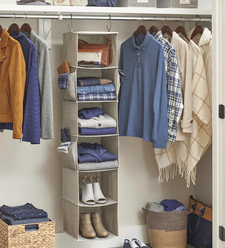 Organized closet with hanging clothes, folded items, and shoes neatly arranged