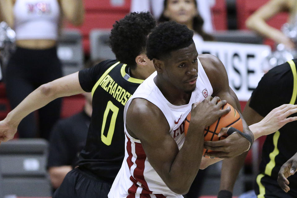 Washington State guard TJ Bamba, front, secures a rebound next to Oregon guard Will Richardson during the second half of an NCAA college basketball game Sunday, Feb. 19, 2023, in Pullman, Wash. Washington State won 68-65. (AP Photo/Young Kwak)