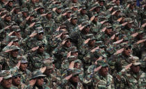 Protesting army soldiers salute as they sing their national anthem as they march through La Paz, Bolivia, Thursday, April 24, 2014. Hundreds of low ranking soldiers from Bolivia's Armed Forces marched for a third day against the military high command's dismissal of four of its leaders who defended their call for better career opportunities. Enlisted men are demanding changes so that non-commissioned officers in Bolivia's military may study to become career officers. (AP Photo/Juan Karita)