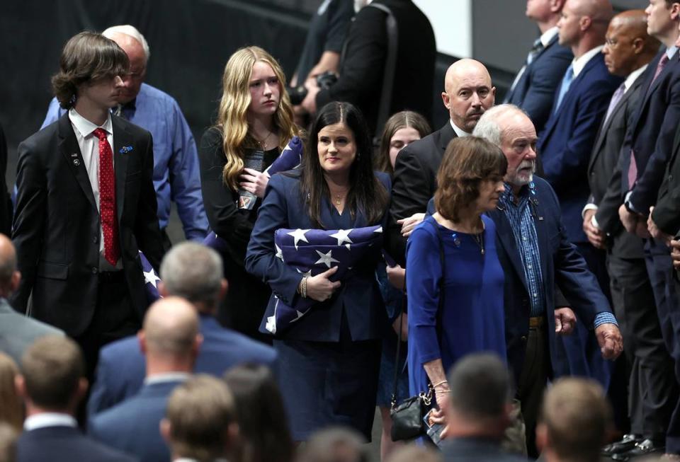Kelly Weeks, center, the widow of slain Deputy U.S. Marshal Thomas Weeks Jr., glances over at attendees of her husband’s memorial service at Bojangles Coliseum in Charlotte, NC on Monday, May 6, 2024. U.S. Marshal Weeks Jr., died during a standoff with a gunman on Monday, April 29th 2024.