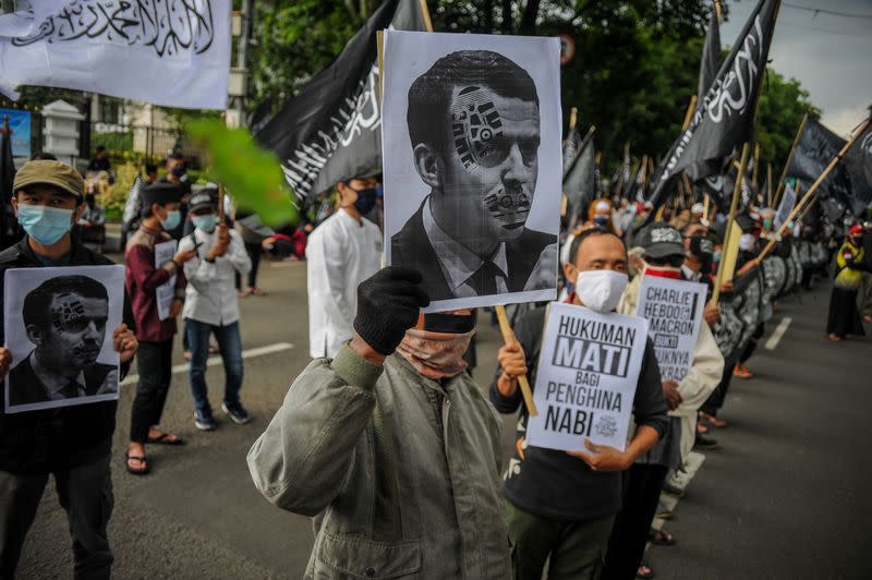 Protesters hold the pictures of French President Emmanuel Macron during a protest against Macron's comments considered insulting to Islam and the Prophet Muhammad