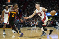 Miami Heat guard Tyler Herro (14) drives as Atlanta Hawks guard Delon Wright (0) defends during the second half of an NBA basketball game Friday, April 8, 2022, in Miami. The Heat won 113-109. (AP Photo/Lynne Sladky)